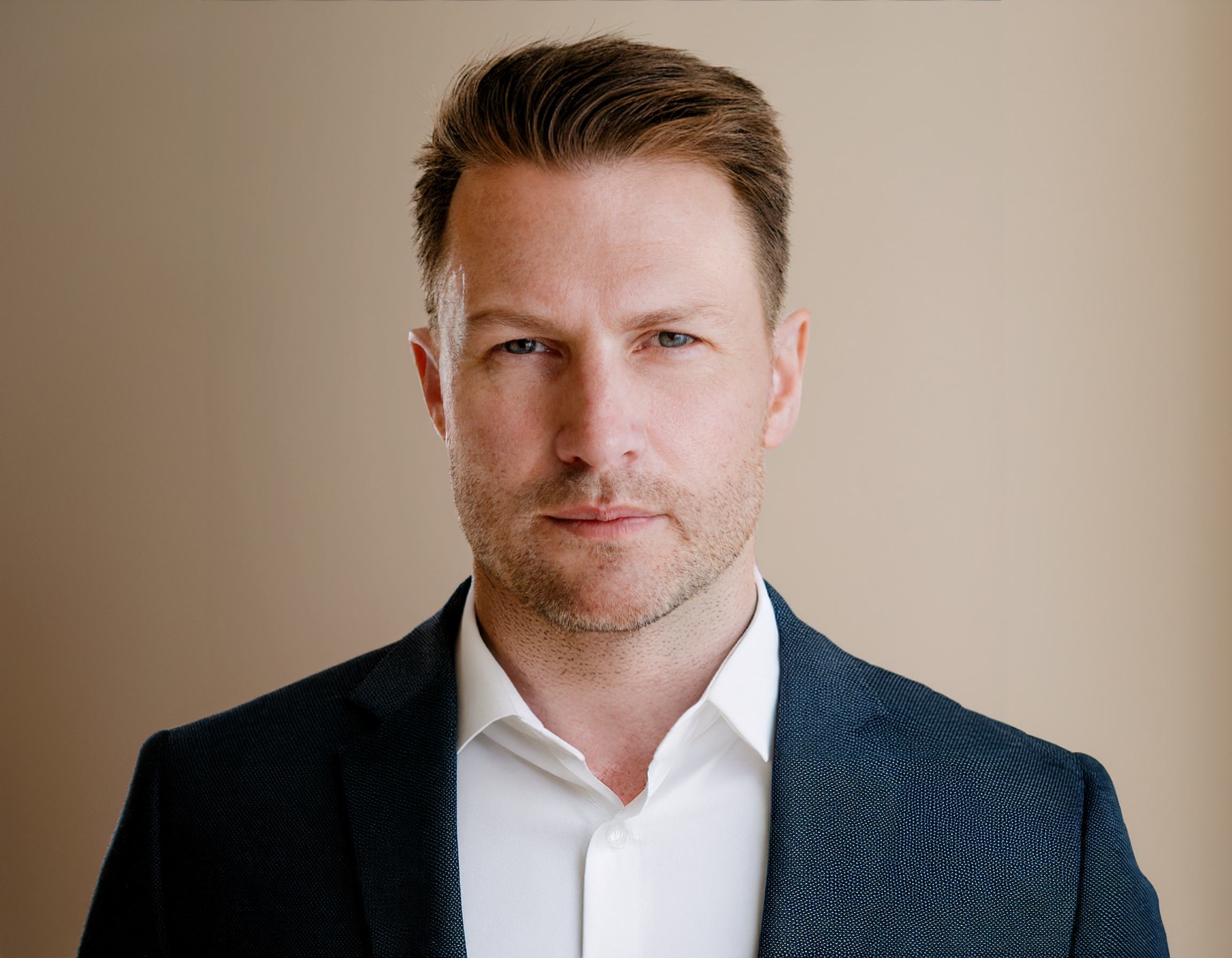 Bernd Rumpf, professionell gekleidet, vor einem neutralen Hintergrund